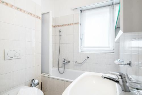 a bathroom with a shower and a sink and a toilet at Lido Apartments by Quokka 360 - 5 min from the centre and the Lugano Lido in Lugano