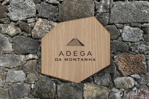 a wooden sign on a stone road at Adegas do Pico in São Roque do Pico