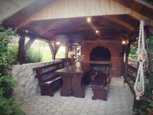 d'une terrasse avec une table, des bancs et un four en briques. dans l'établissement Kuća Grič, Mrzla Vodica, à Mrzla Vodica