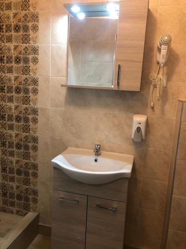 a bathroom with a sink and a shower at Mosoly Szallashely in Szeged