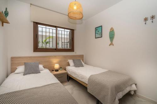 una camera da letto con due letti e una finestra di Palmera a San Juan de los Terreros