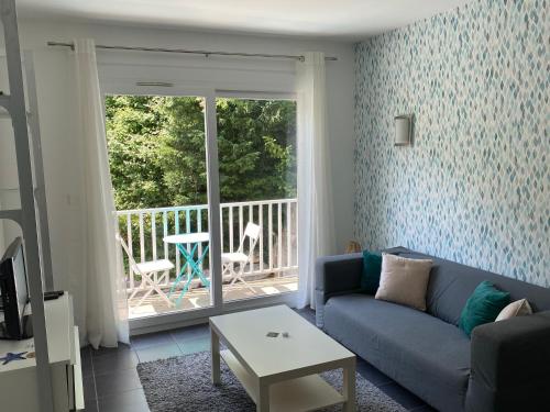 a living room with a blue couch and a balcony at PETIT NID AU BOURGET DU LAC in Le Bourget-du-Lac