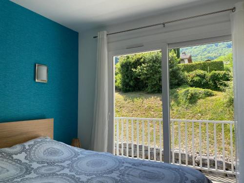 - une chambre avec un lit et une grande fenêtre dans l'établissement PETIT NID AU BOURGET DU LAC, au Bourget-du-Lac