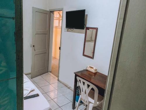 um quarto com uma mesa, um espelho e uma porta em Hotel América no Recife