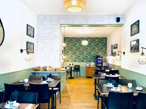 a dining room with tables and chairs in a restaurant at Hôtel Gaspard in Le Touquet-Paris-Plage