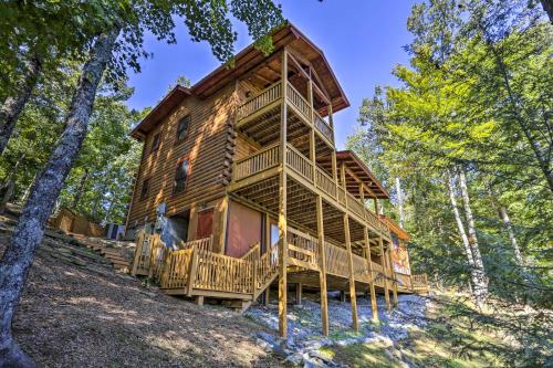 una gran cabaña de madera en el bosque con árboles en Lovely Log Cabin and Bunkhouse with Views and Yard!, en Cherry Log