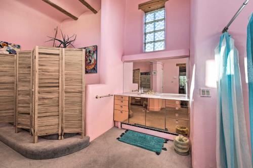 La salle de bains est pourvue de murs roses, d'un lavabo et d'un miroir. dans l'établissement El Prado Home with Hot Tub, Panoramic Mtn Views, à El Prado
