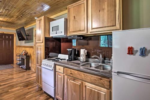 a kitchen with wooden cabinets and a white refrigerator at Silver Creek Cabin with Hiking Less Than 1 Mi to Town! in Beattyville