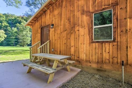 a wooden cabin with a bench in front of it at Silver Creek Cabin with Hiking Less Than 1 Mi to Town! in Beattyville