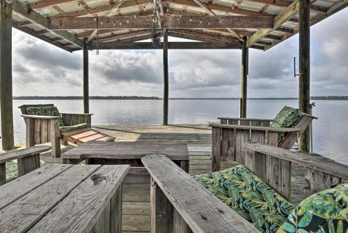 a wooden dock with benches and chairs on the water at Pirate Cove Home in Welaka Dock and River Access! in Welaka