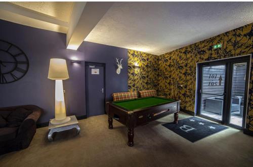 ein Wohnzimmer mit einem Billardtisch und einer Lampe in der Unterkunft Cit'Hotel B Hotel in Béthune