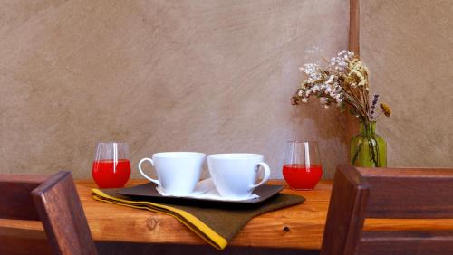 a table with two coffee cups and a vase of flowers at Folia in Rome