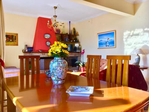 a dining room table with a vase of flowers on it at Delphi celebrity v i p the navel of the Earth, CENTER-DELPHI-penthouse galaxy&sky panoramic view, harmony&YOGA in Delphi