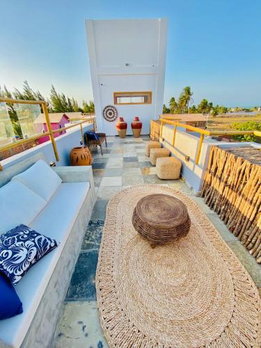 a patio with a white couch and a large hat at Pousada Sole - D3 Experience - Preá, CE in Prea