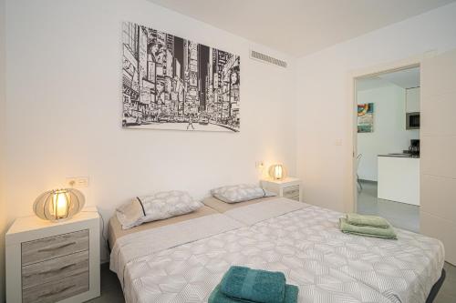 biała sypialnia z łóżkiem i zdjęciem na ścianie w obiekcie Flamingo playa 8 w mieście San Pedro del Pinatar