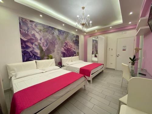 two beds in a room with a painting on the wall at Maison De luxe in Pompei