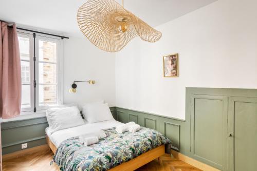 - une chambre avec un lit et un ventilateur dans l'établissement AMOUR - Appartement chaleureux et moderne dans le cœur historique de Rennes, à Rennes