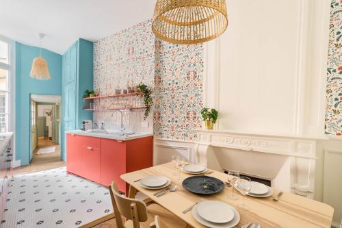 une cuisine avec une table en bois et une salle à manger dans l'établissement AMOUR - Appartement chaleureux et moderne dans le cœur historique de Rennes, à Rennes
