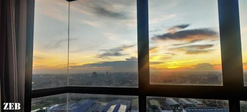 a view of a sunset from an office window at i-City-Casa Joy - Wifi, Netflix - Movies, Parking, Sleeps 7 Pax in Kampong Padang Jawa