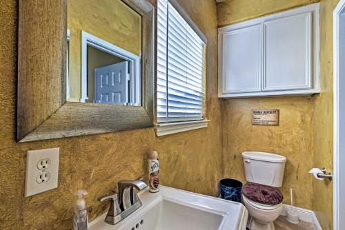 a bathroom with a sink and a toilet and a mirror at Walk to Ocean Lakefront Dickinson Stucco House! in Dickinson