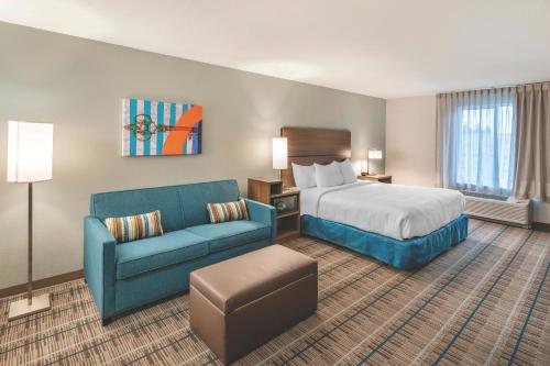 a hotel room with a bed and a blue couch at MainStay Suites Murfreesboro in Murfreesboro