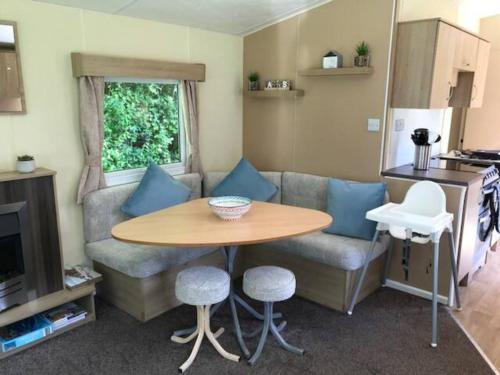 ein Wohnwagen-Wohnzimmer mit einem Tisch und einem Sofa in der Unterkunft Jubilee Lower Hyde Isle of Wight - Kingsgate 23 in Shanklin