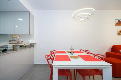 a dining room with a red and white table and chairs at Kokopelli in San Juan de los Terreros
