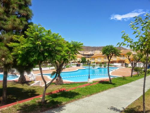 una piscina in un resort con palme di Holiday Rental, El Poblet, El Campello, Alicante ad Alicante