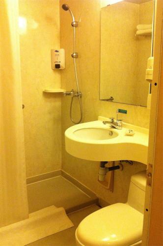 a bathroom with a sink and a toilet and a mirror at Jinjiang Inn Changsha Dongfeng Road in Changsha