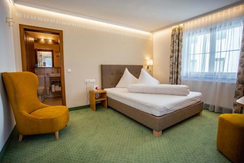 a hotel room with a bed and a chair at Pension Inge in Sankt Anton am Arlberg