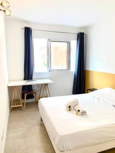 une chambre avec un lit, un bureau et une fenêtre dans l'établissement Spacious apartment in the heart of Juan les Pins !, à Juan-les-Pins