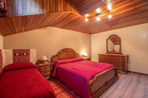 a bedroom with two beds and a mirror at L'Atelier du Temps - HERBETET Appartement in Cogne