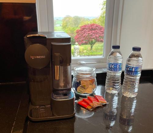 a coffee maker and two bottles of water on a counter at 1-Bed luxury studio Apartment Cockermouth in Cockermouth