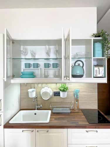 a kitchen with white cabinets and a sink at Apartmani Madera in Kopaonik