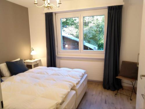 - une chambre avec un lit et une grande fenêtre dans l'établissement Leuca 25, à Loèche-les-Bains