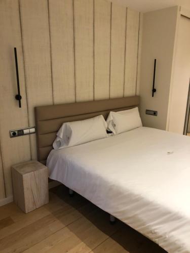 a bed with white sheets and pillows in a room at Luxury Apartment with Jacuzzi in Santiago de Compostela