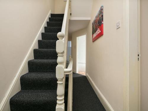 una escalera con alfombra negra y una escalera negra en Short Term Shared R&R In Chorlton en Mánchester