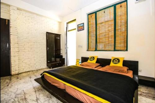 a bedroom with a large bed with yellow pillows at Heistel Delhi in New Delhi