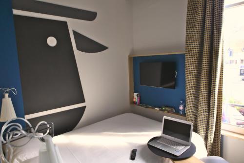 a computer desk with a laptop and a monitor at ibis Styles Moulins Centre in Moulins