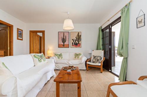 ein Wohnzimmer mit weißen Sofas und einem Couchtisch in der Unterkunft Villa Mariposa in Playa Blanca