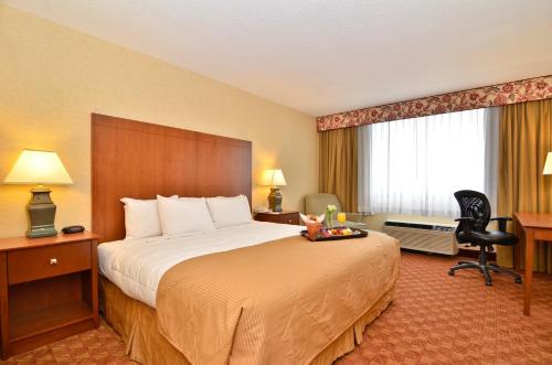 a hotel room with a large bed and a desk at Clarion Hotel Airport Portland in Portland