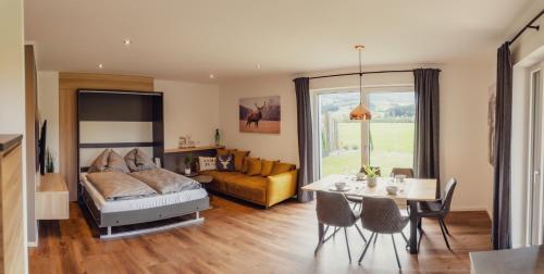 a bedroom with a bed and a table and a couch at Aberle Apartments in Rossleithen