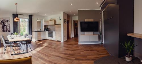 a living room with a dining room table and a kitchen at Aberle Apartments in Rossleithen