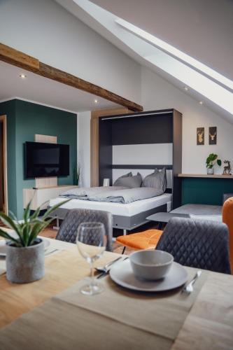 a bedroom with a large bed and a dining table at Aberle Apartments in Rossleithen