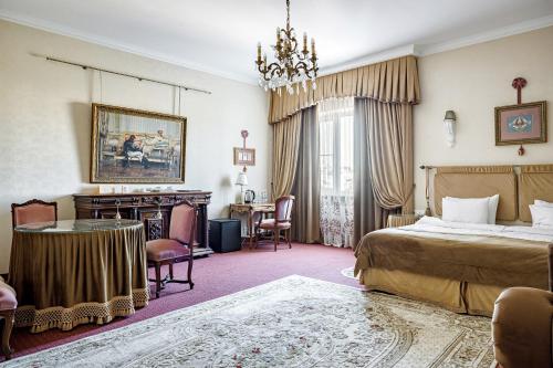 1 dormitorio con 1 cama, mesa y sillas en Bristol Hotel, en Krasnodar