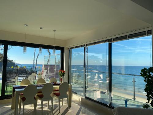 a dining room with a table and views of the ocean at Penthouse BlueSky in Rewal