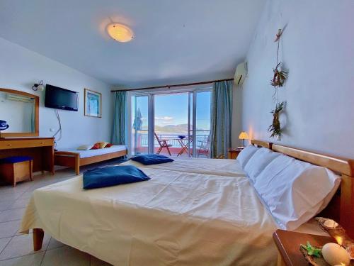 a bedroom with a bed with a view of the ocean at SeaFront Villa Ourania in Mesongi