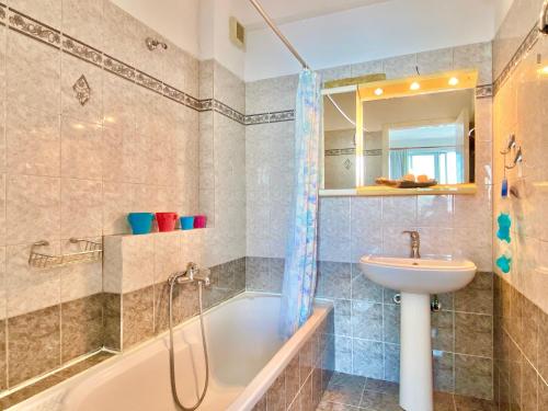 a bathroom with a tub and a sink and a shower at SeaFront Villa Ourania in Mesongi