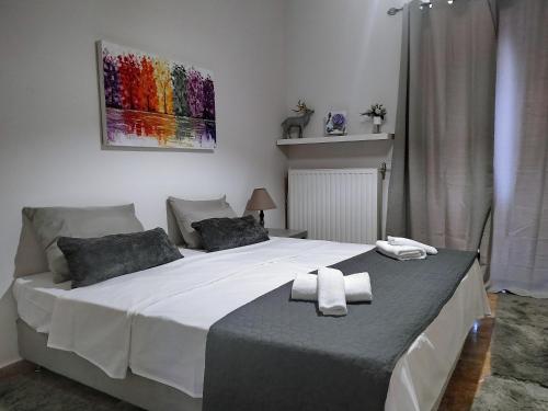 a bedroom with a large white bed with two towels on it at Villa Arcadia in Vlakhérna