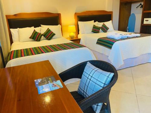 a hotel room with two beds and a table at La Isla Resort in Caye Caulker